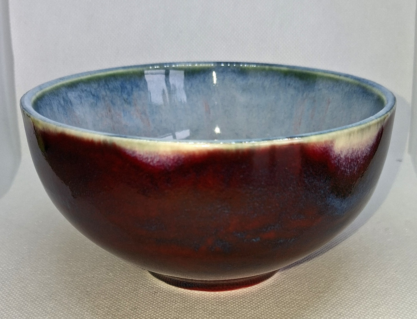 Ceramic bowl with a gradient from blue to red on a white background