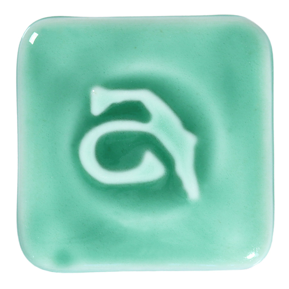 Abbots Lucent Emerald glaze swatch showing it pools into richer tones in recessed areas and softens across edges, maintaining a clear, fluid surface.