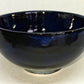 Glossy black ceramic bowl on a light gray background