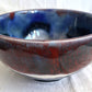 Ceramic bowl with blue and red glaze on a white background