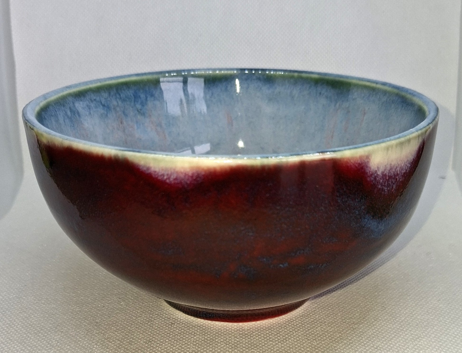 Ceramic bowl with a gradient from blue to red on a white background